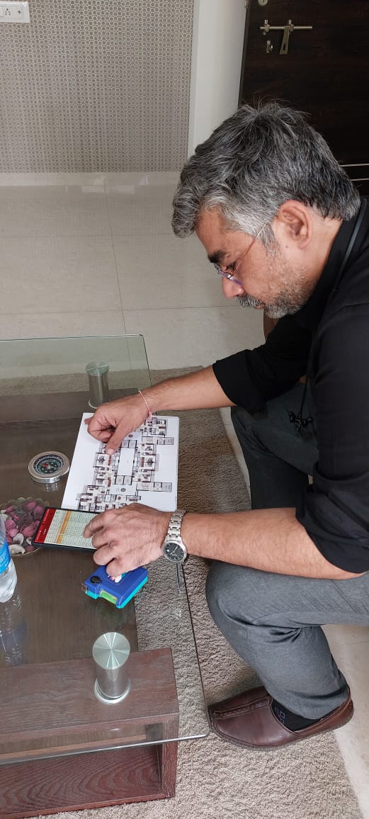 Aacharya Chintan Anand Chande analysing a floor plan with a compass for Vastu